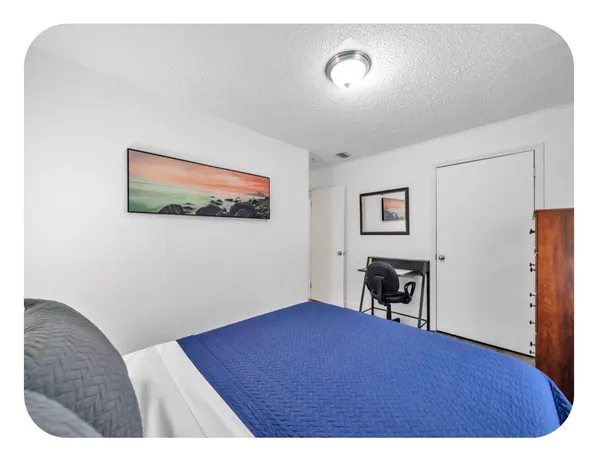 a bedroom with a bed and a painting on the wall