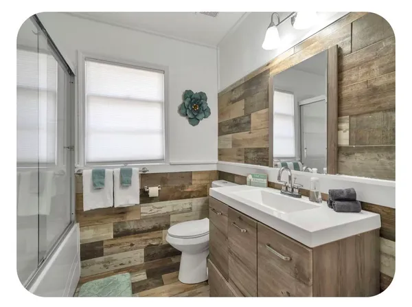 a bathroom with a sink double vanity mirror and a bathtub