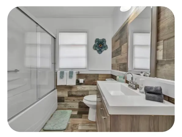 a bathroom with a sink and mirror with toilet