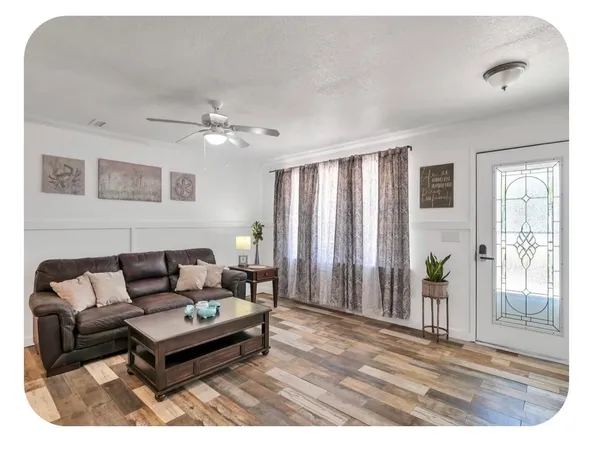 a living room with furniture and a ceiling fan