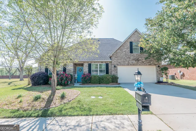 a front view of a house with a yard and potted plants