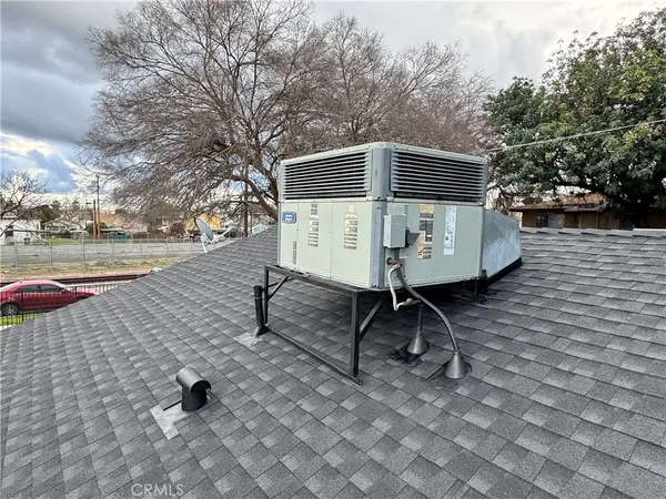 a small white building with a bench next to a yard