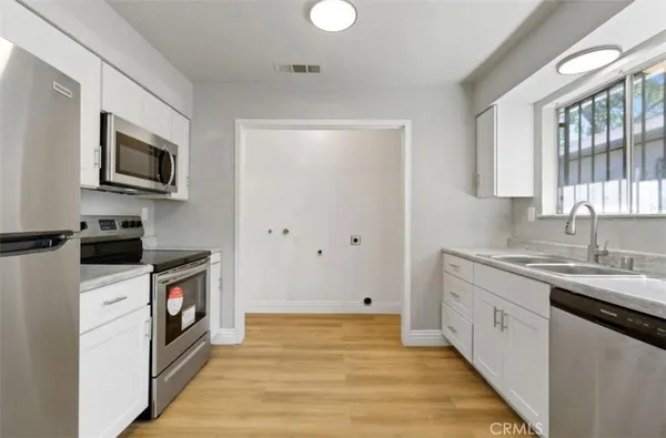a kitchen with a sink and steel appliances