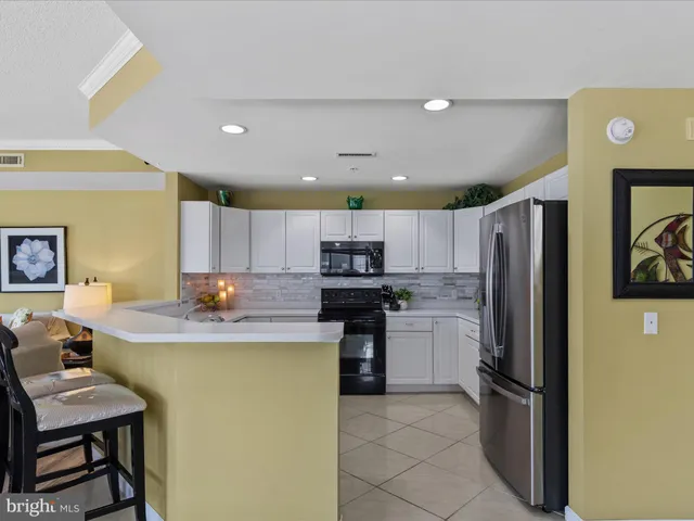 a kitchen with white cabinets and appliances