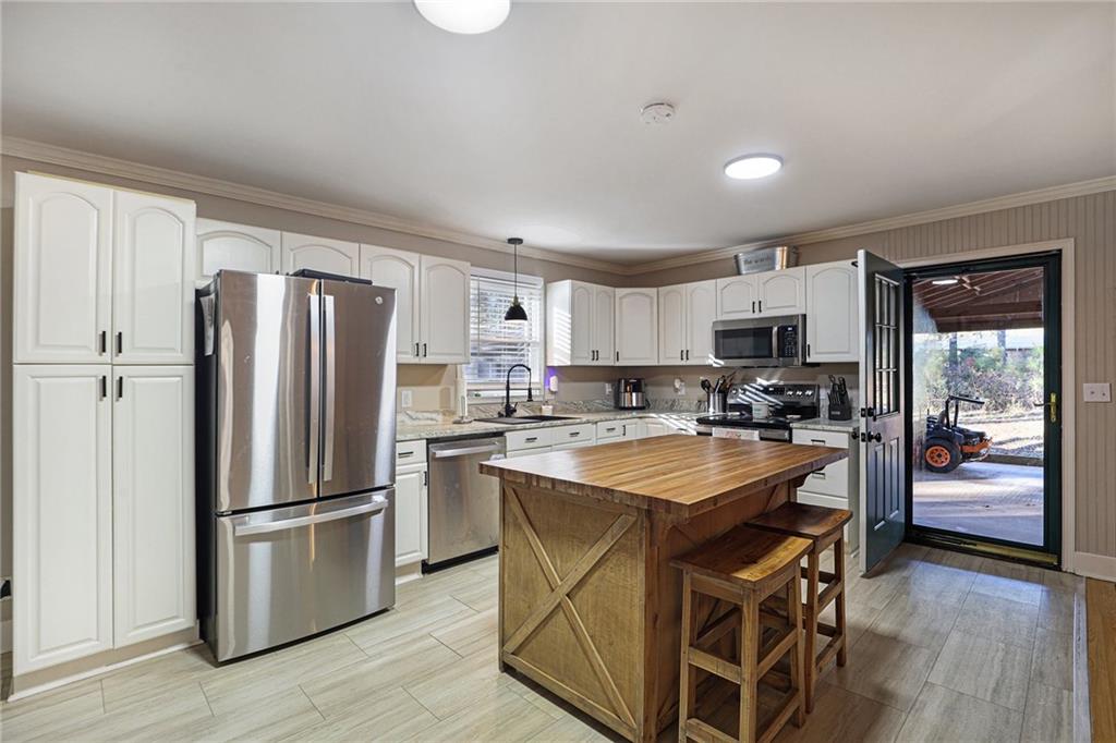 315 Laurel Road Carrollton, GA 30117 - Photo 13 of 30 a kitchen with stainless steel appliances granite countertop a refrigerator a stove top oven a sink dishwasher and a refrigerator with wooden floor