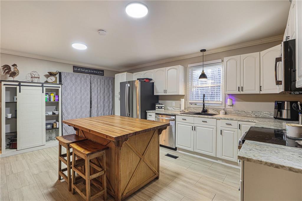 315 Laurel Road Carrollton, GA 30117 - Photo 16 of 30 a kitchen with stainless steel appliances granite countertop refrigerator sink and cabinets