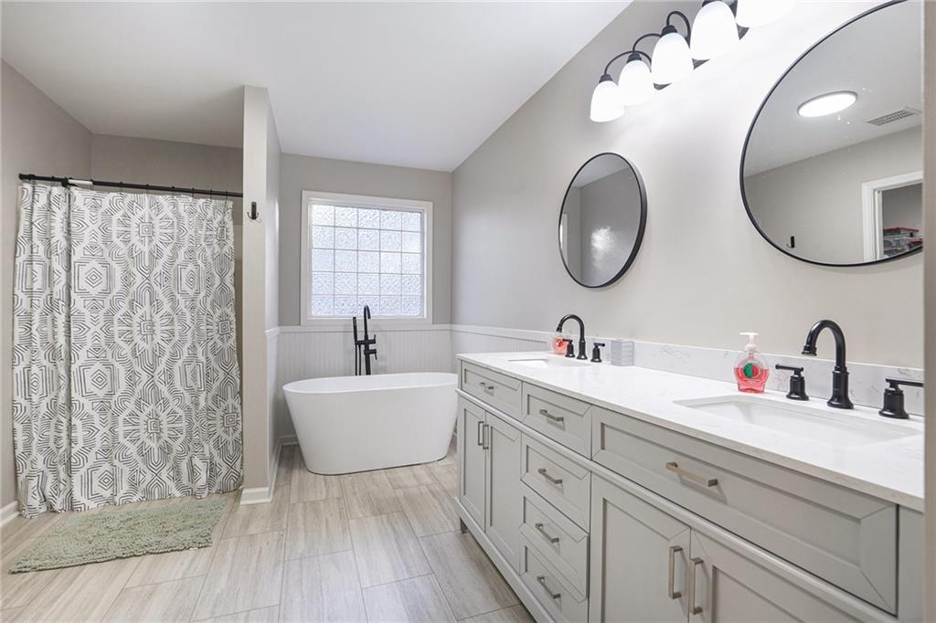 315 Laurel Road Carrollton, GA 30117 - Photo 22 of 30 a bathroom with a double vanity sink mirror and bathtub