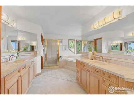 a large bathroom with a granite countertop double vanity and a large mirror