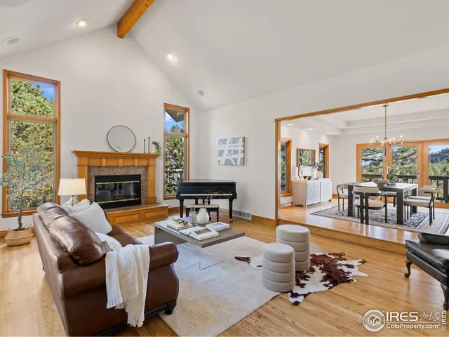 a living room with fireplace furniture and a large window