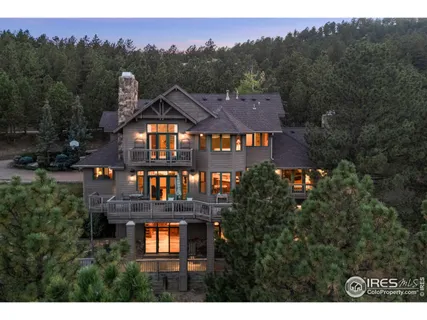 a view of a big house with a big yard and large trees