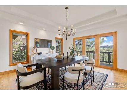 a dining room with furniture a chandelier and wooden floor