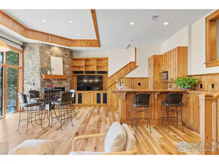 a living room with kitchen view and a dining table with wooden floor
