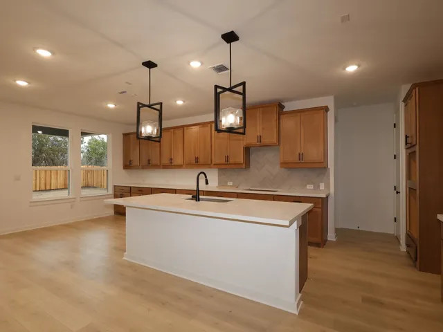 a large kitchen with stainless steel appliances kitchen island a large counter top and a wooden floors