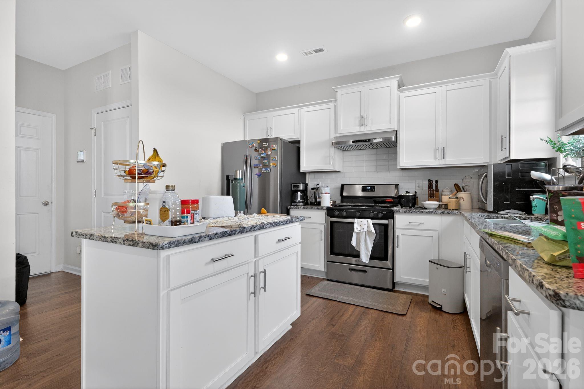 137 North Ranney Way Mooresville, NC 28117 - Photo 4 of 30 a kitchen with white cabinets and stainless steel appliances
