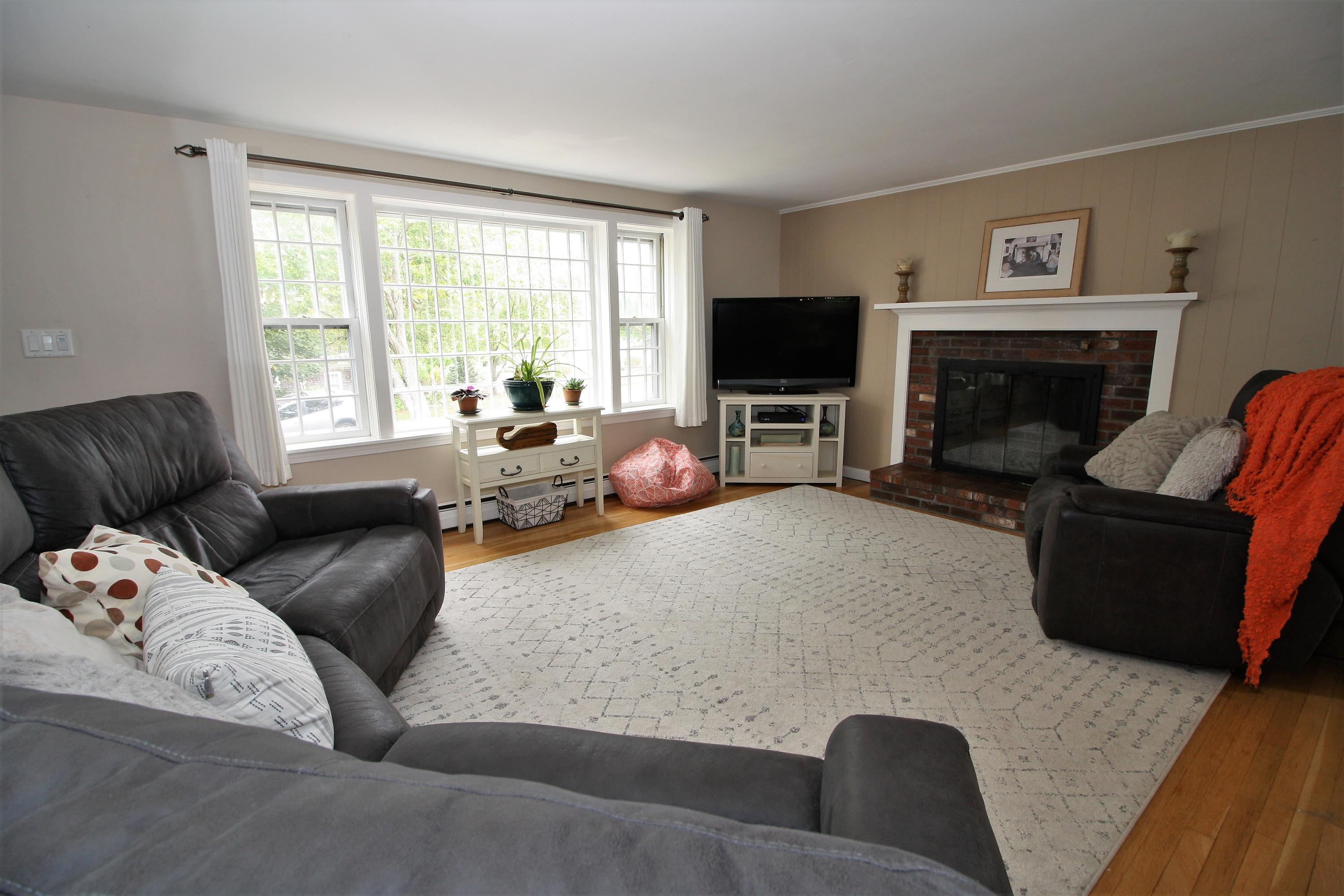 109 Pompano Road Yarmouth Port, MA 02675 - Photo 2 of 42 a living room with furniture a flat screen tv and a fireplace