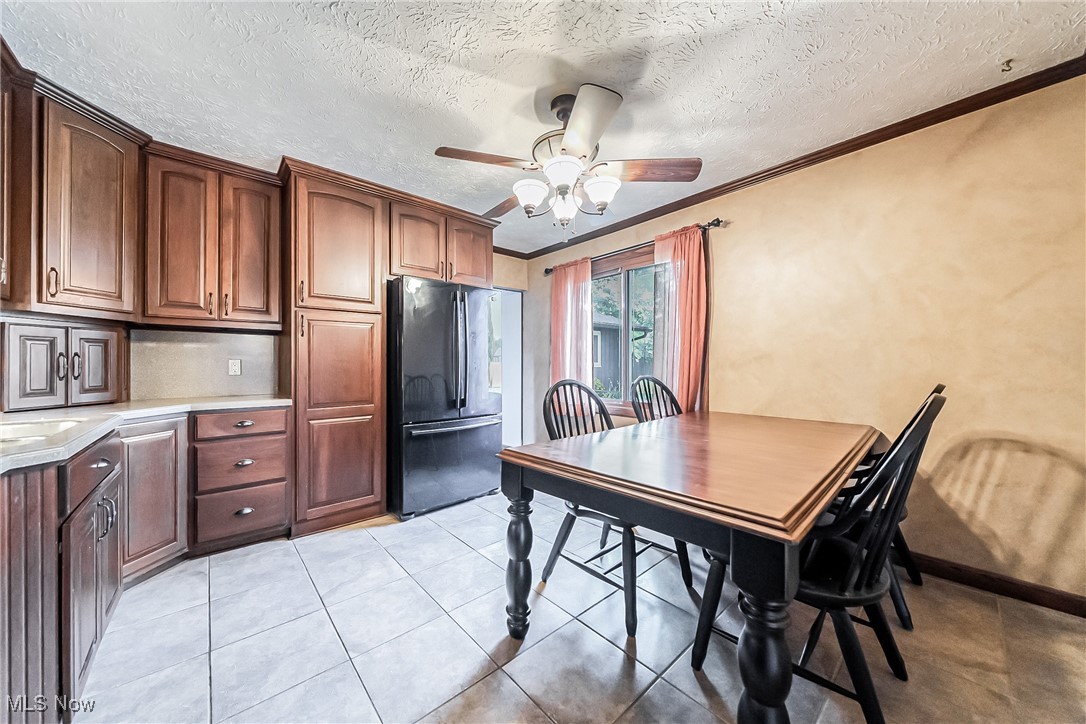 43385 Kipton Nickle Plate Road Lagrange, OH 44050 - Photo 11 of 37 Tiled dining space with ceiling fan, crown molding, and a textured ceiling