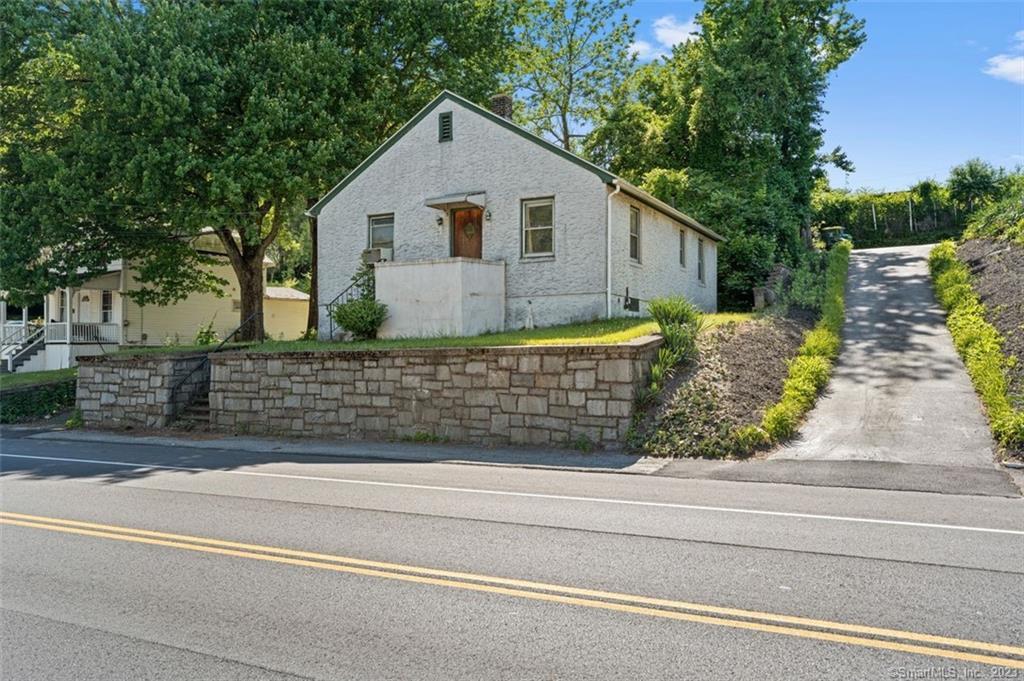 243 Woodtick Road Waterbury, CT 06705 - Photo 1 of 1 a view of a house with a small yard and large trees