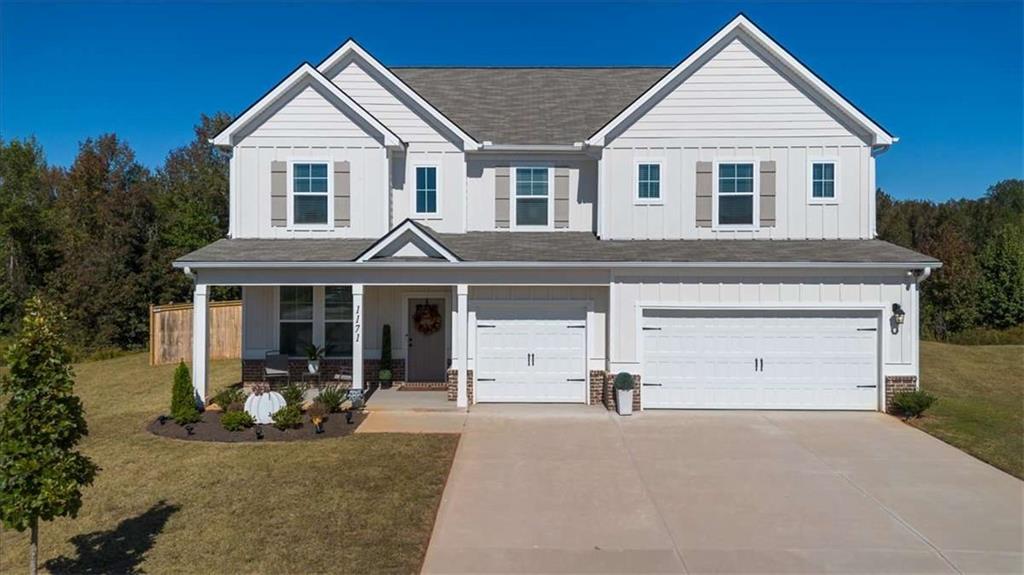 a view of a white house with large windows and a small yard