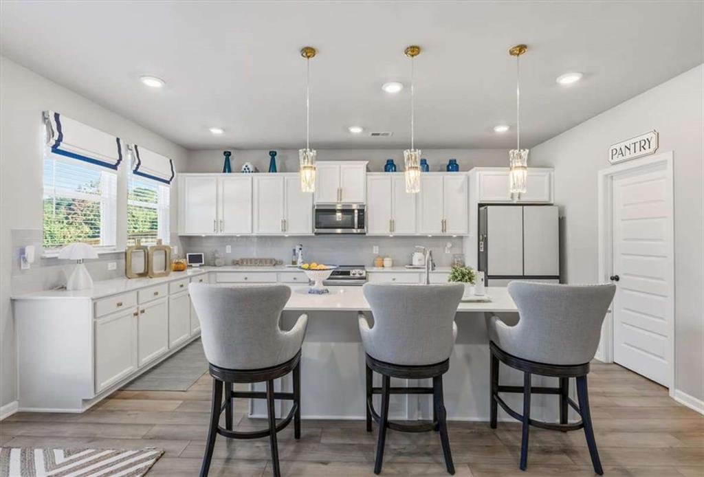 1171 Bodega Loop Locust Grove, GA 30248 - Photo 12 of 57 a kitchen with kitchen island wooden cabinets and refrigerator