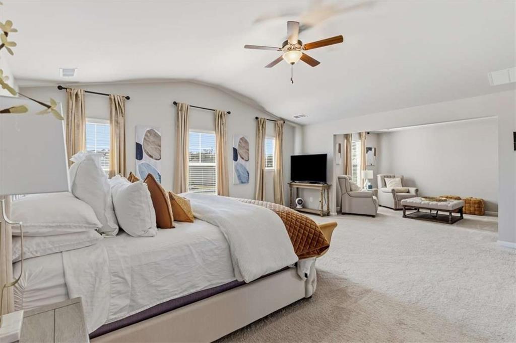 1171 Bodega Loop Locust Grove, GA 30248 - Photo 23 of 57 a bedroom with a bed a couch and a flat screen tv