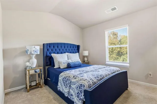 a bedroom with a bed and a lamp