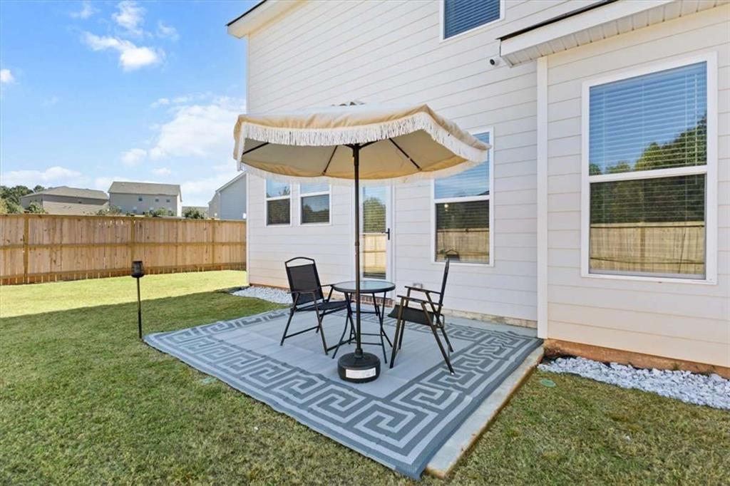1171 Bodega Loop Locust Grove, GA 30248 - Photo 43 of 57 a table and chairs in front of a house