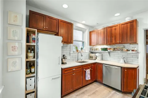 a kitchen with a sink refrigerator and cabinets