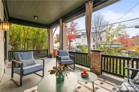 a balcony with chairs and wooden floor