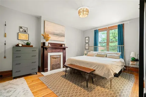 a bedroom with a bed and a dresser next to a window