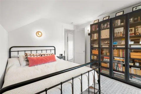a bedroom with a bed and a book shelf