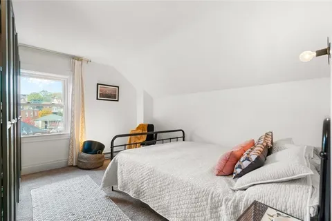a bedroom with a bed and a lamp next to a window