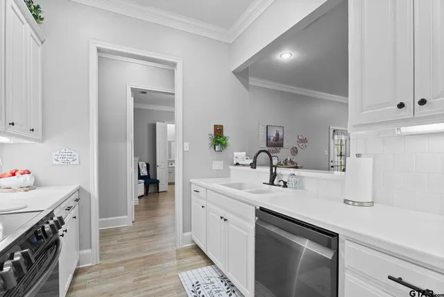 a kitchen with a sink dishwasher a stove and a refrigerator with wooden floor