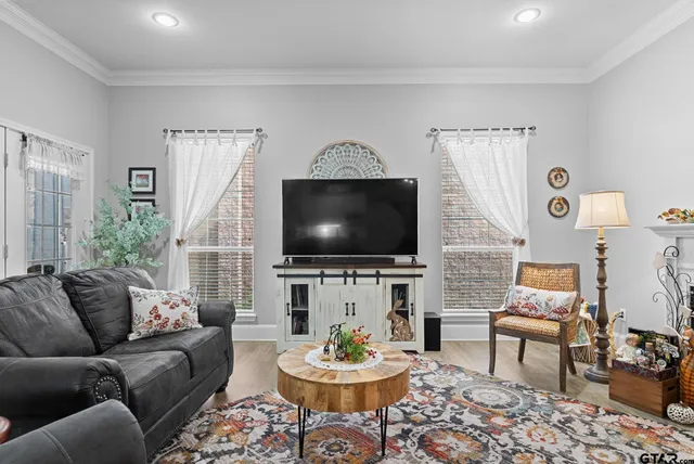 a living room with furniture a flat screen tv and a window