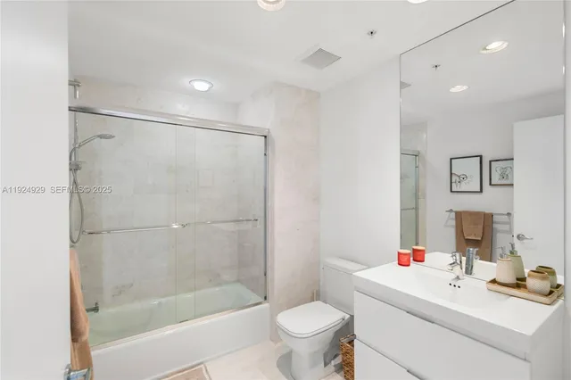 a living room with furniture a flat screen tv and a floor to ceiling window