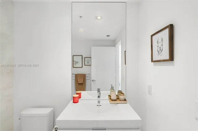 a living room with stainless steel appliances kitchen island granite countertop a sink and cabinets