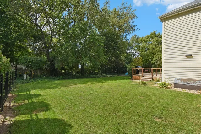 a backyard of a house with plants and large trees