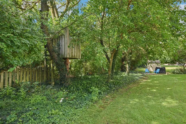 a backyard of a house with lots of green space and fountain