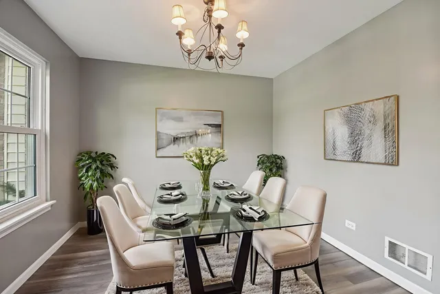 a view of a dining room with furniture a chandelier and wooden floor