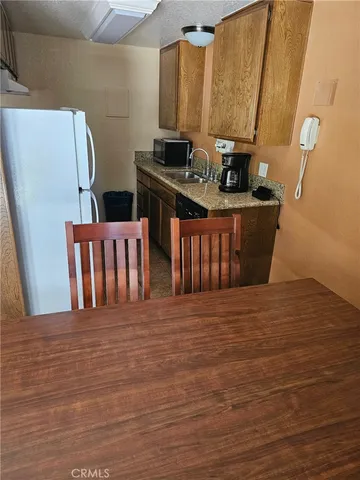 a view of a kitchen with stainless steel appliances wooden floor and a refrigerator
