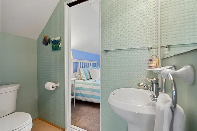 a bathroom with a toilet sink and mirror