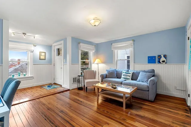 a living room with furniture and a wooden floor