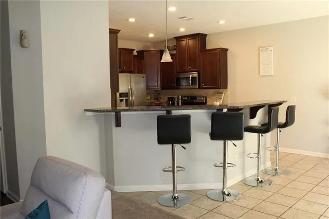 a kitchen with stainless steel appliances granite countertop a refrigerator and a stove top oven