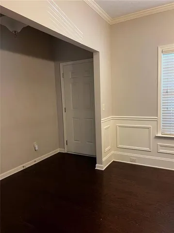 a view of empty room with wooden floor and windows
