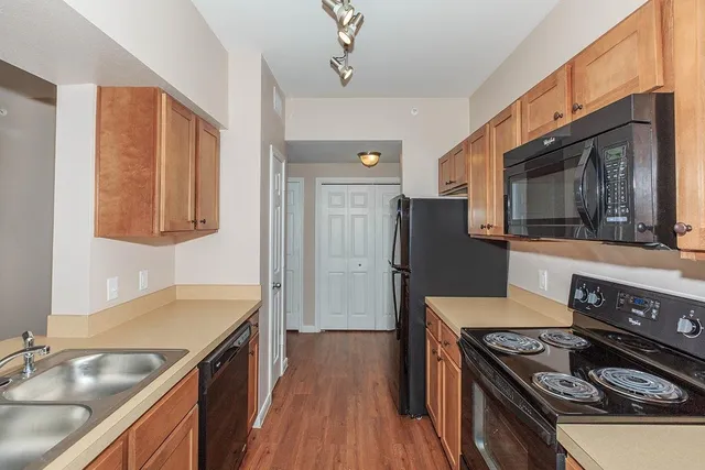 a kitchen with stainless steel appliances granite countertop a stove refrigerator and microwave