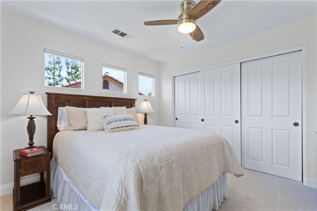 142 Via Camelia Paso Robles, CA 93446 - Photo 25 of 43 a bedroom with a large bed and a chandelier