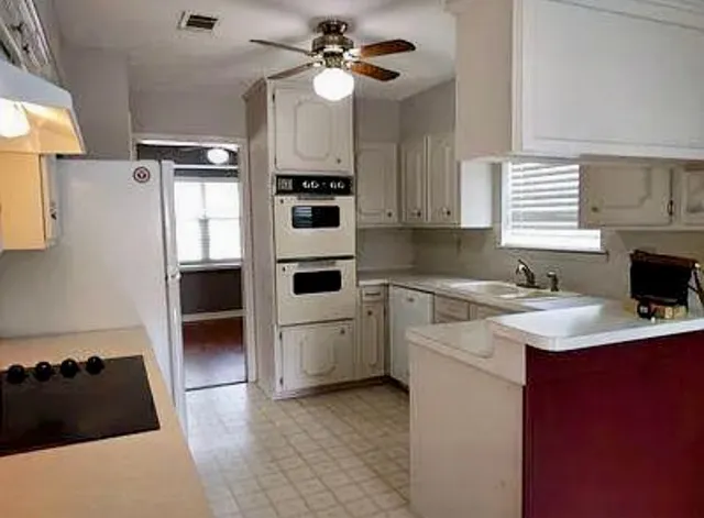 a kitchen with a sink appliances and cabinets