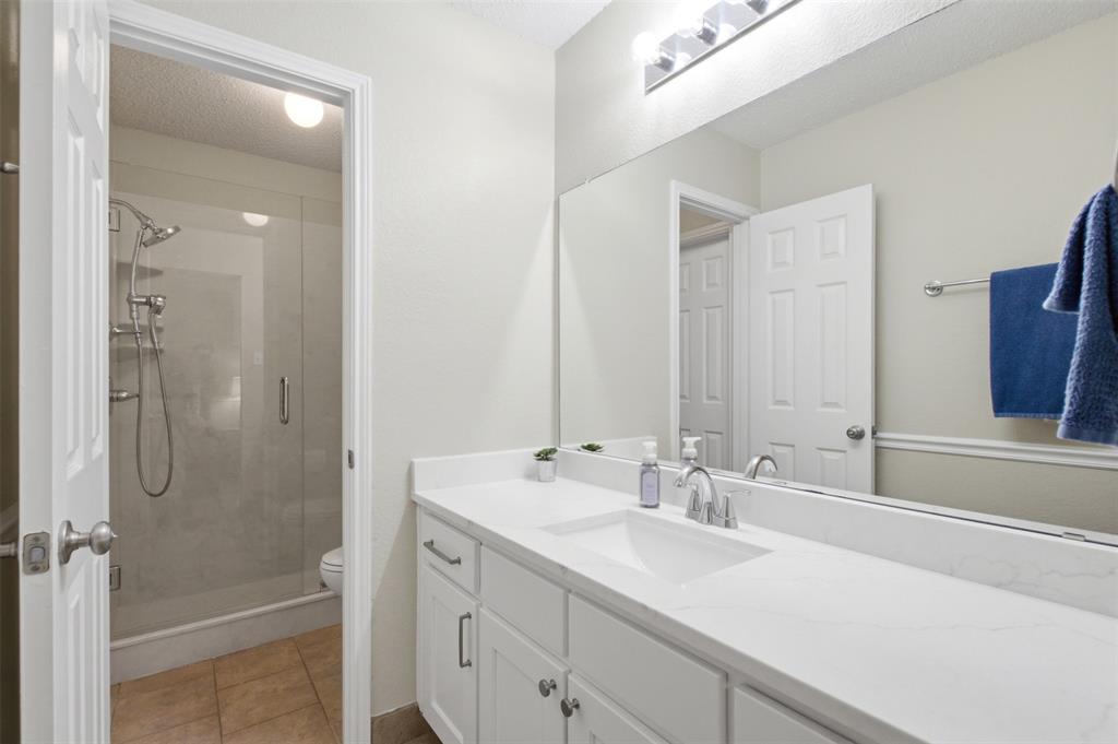 4218 Glistening Spring Rowlett, TX 75088 - Photo 26 of 39 Jack-'n-Jill Bathroom featuring a dual-sink vanity with white cabinetry, a single polished chrome faucet, and a large wall-mounted mirror