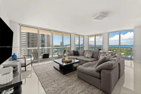 a living room with furniture large windows and a flat screen tv