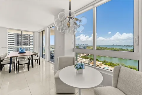 a dining room with furniture a chandelier and wooden floor