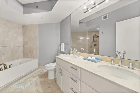 a bathroom with a double vanity sink toilet and shower
